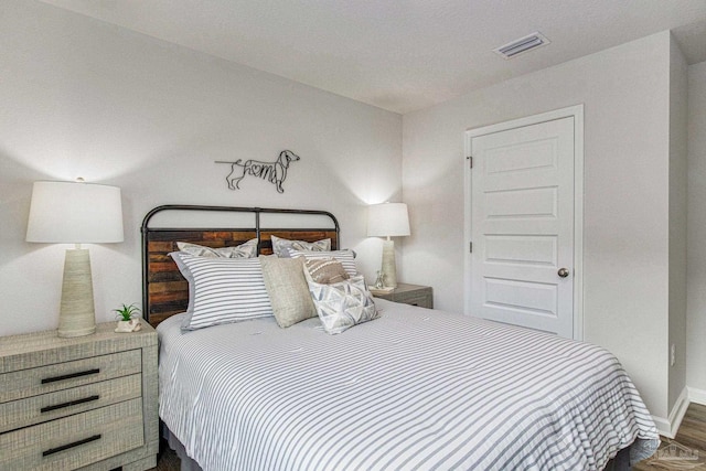 bedroom featuring visible vents, wood finished floors, and baseboards