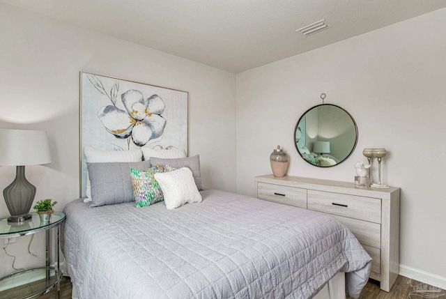 bedroom with wood finished floors and visible vents