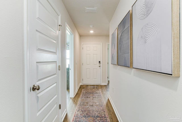 entryway featuring baseboards, visible vents, and wood finished floors