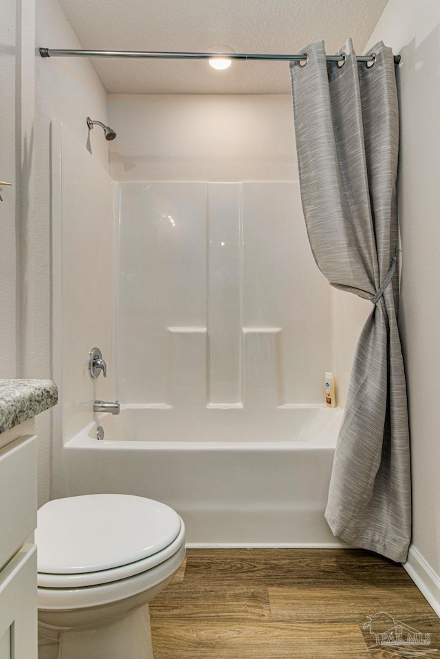 full bathroom featuring wood finished floors, toilet, tub / shower combination, and vanity