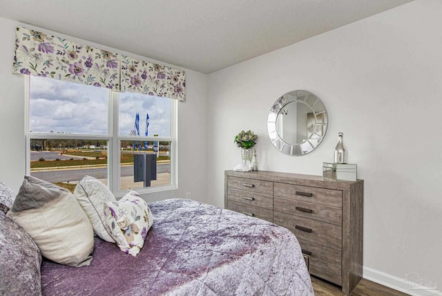 bedroom featuring wood finished floors and baseboards