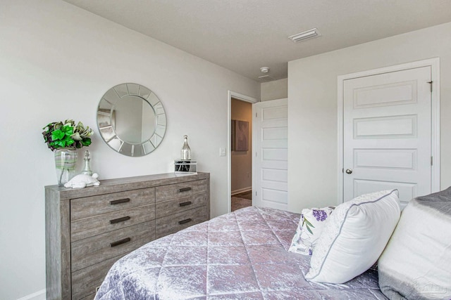 bedroom featuring visible vents and baseboards