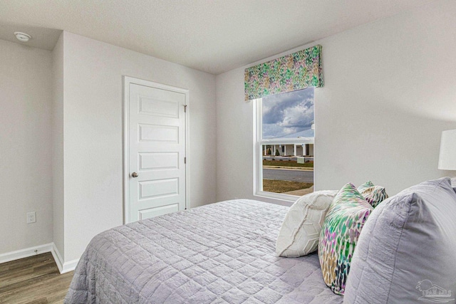 bedroom with baseboards and wood finished floors