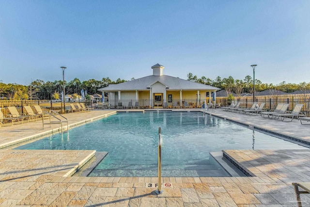 pool featuring fence and a patio area
