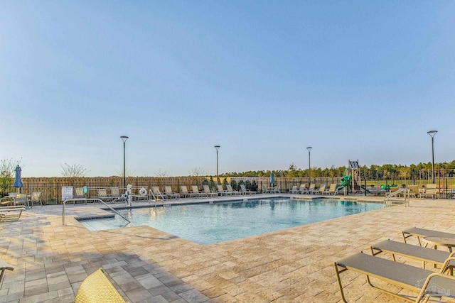 pool with fence and a patio area