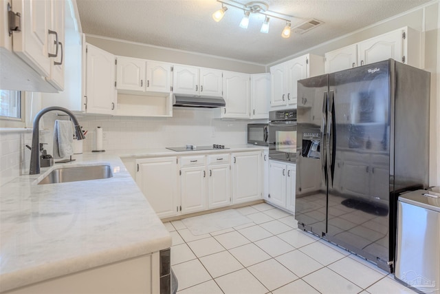 kitchen with white cabinetry, sink, light tile patterned floors, and black appliances