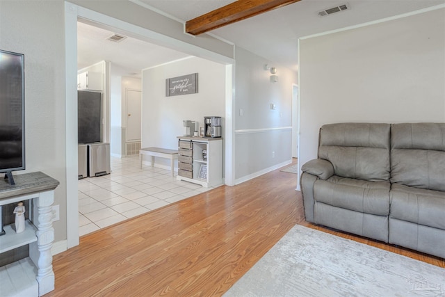 living room featuring beam ceiling and light hardwood / wood-style floors