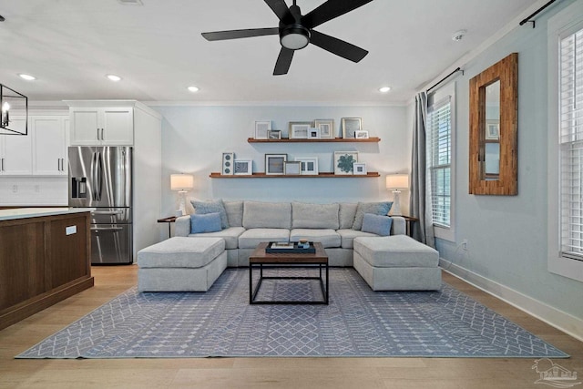 living area featuring ceiling fan, recessed lighting, baseboards, light wood finished floors, and crown molding