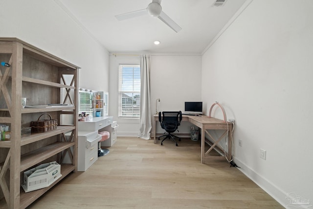 office featuring ceiling fan, light wood-style flooring, visible vents, baseboards, and crown molding