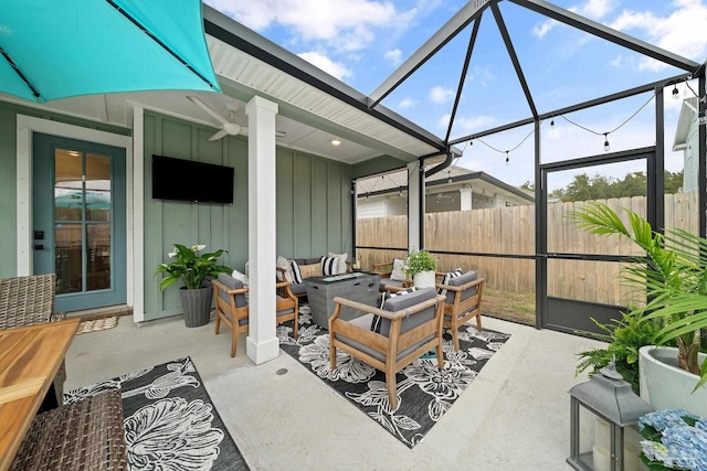 view of patio featuring ceiling fan, fence, an outdoor living space, and a lanai