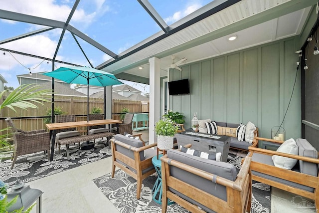 view of patio / terrace with a lanai, an outdoor hangout area, fence, and outdoor dining area