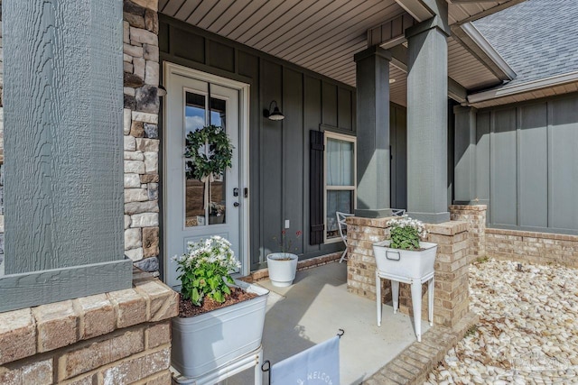 1058 Iron Forge Rd, Cantonment, FL 32533 - doorway to property featuring board and batten siding, a porch, a shingled roof, and stone siding