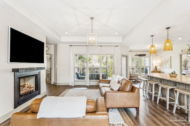 1058 Iron Forge Rd, Cantonment, FL 32533 - living area featuring a tray ceiling, dark wood-type flooring, a warm lit fireplace, and recessed lighting