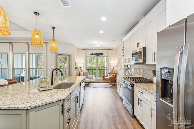 1058 Iron Forge Rd, Cantonment, FL 32533 - kitchen with appliances with stainless steel finishes, a sink, open floor plan, tasteful backsplash, and a center island with sink