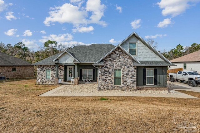 1058 Iron Forge Rd, Cantonment, FL 32533 - craftsman-style house featuring stone siding, a front yard, a shingled roof, board and batten siding, and a porch