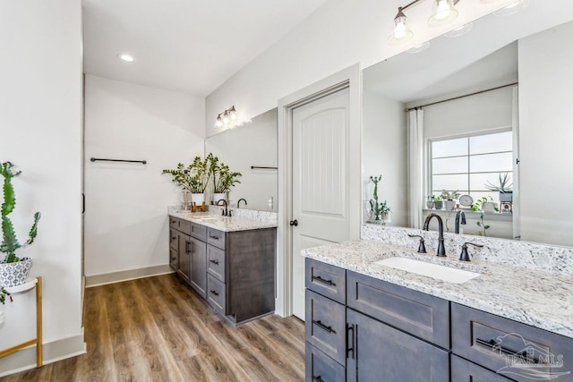 1058 Iron Forge Rd, Cantonment, FL 32533 - bathroom featuring two vanities, wood finished floors, and baseboards