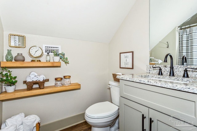 1058 Iron Forge Rd, Cantonment, FL 32533 - bathroom with wood finished floors, toilet, vanity, vaulted ceiling, and baseboards