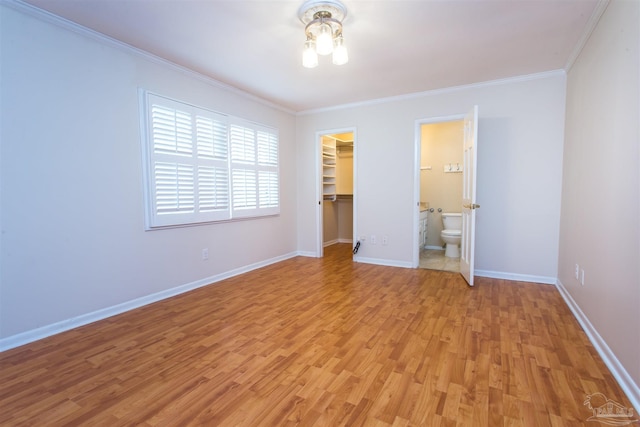 316 Dolphin St, Gulf Breeze, FL 32561 - unfurnished bedroom featuring light wood-type flooring, crown molding, baseboards, a closet, and a walk in closet