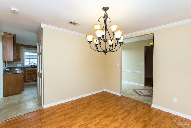 316 Dolphin St, Gulf Breeze, FL 32561 - unfurnished room featuring light wood-style flooring, ornamental molding, a chandelier, baseboards, and a sink