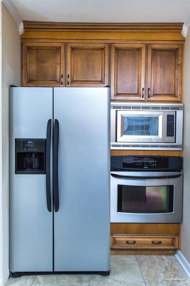 316 Dolphin St, Gulf Breeze, FL 32561 - kitchen with appliances with stainless steel finishes, brown cabinetry, light tile patterned floors, and ornamental molding