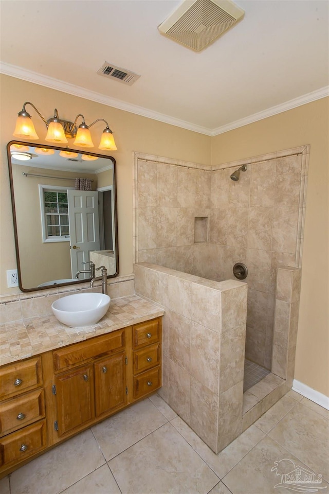 316 Dolphin St, Gulf Breeze, FL 32561 - bathroom featuring a tile shower, ornamental molding, vanity, and tile patterned flooring