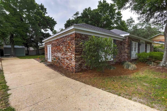 316 Dolphin St, Gulf Breeze, FL 32561 - view of property exterior with a storage shed, brick siding, and an outbuilding
