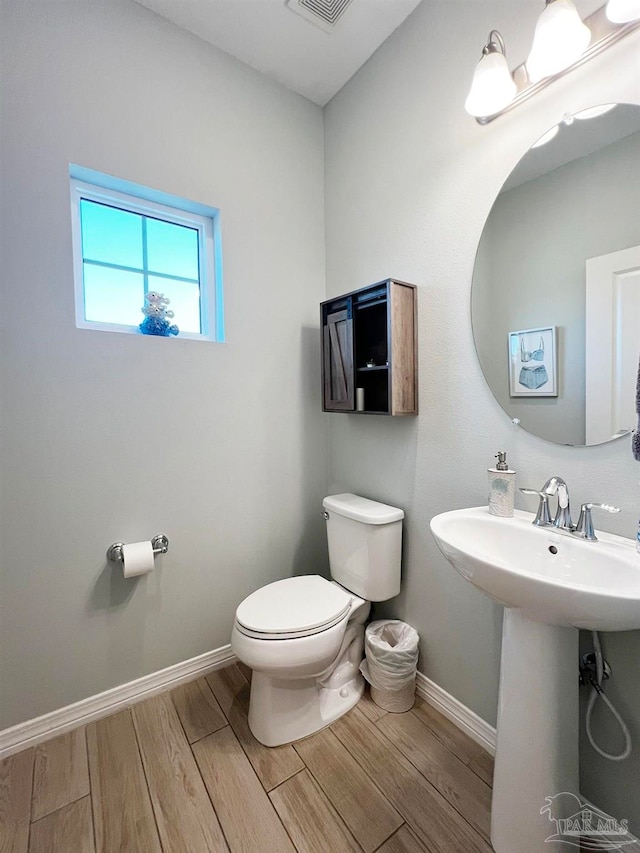 bathroom featuring wood-type flooring and toilet