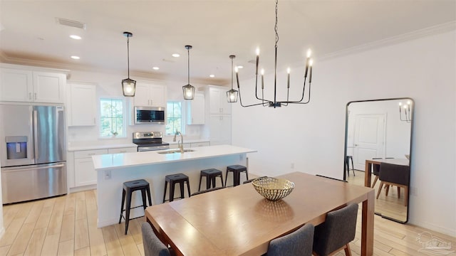 dining space with light hardwood / wood-style flooring, crown molding, and sink