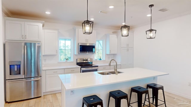 kitchen featuring a center island with sink, pendant lighting, stainless steel appliances, and white cabinets