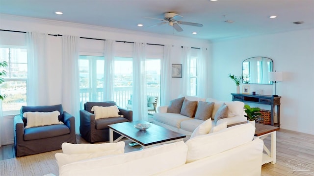 living room with ceiling fan, crown molding, and light hardwood / wood-style floors