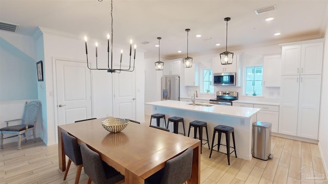 dining room featuring light hardwood / wood-style flooring, crown molding, and sink