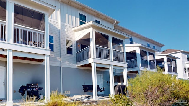 rear view of house with a balcony and a sunroom