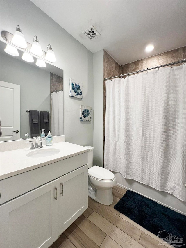 full bathroom featuring wood-type flooring, vanity, toilet, and shower / bath combo with shower curtain