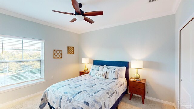 carpeted bedroom with crown molding, ceiling fan, and a closet