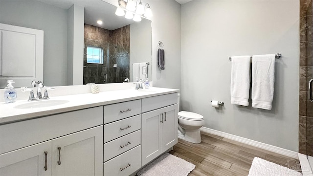 bathroom featuring vanity, toilet, hardwood / wood-style floors, and a shower with door