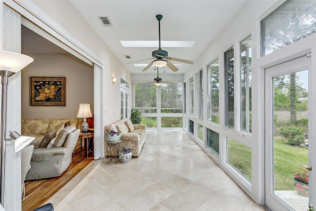 sunroom featuring ceiling fan and a skylight