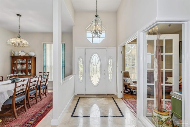 foyer entrance featuring a towering ceiling and an inviting chandelier