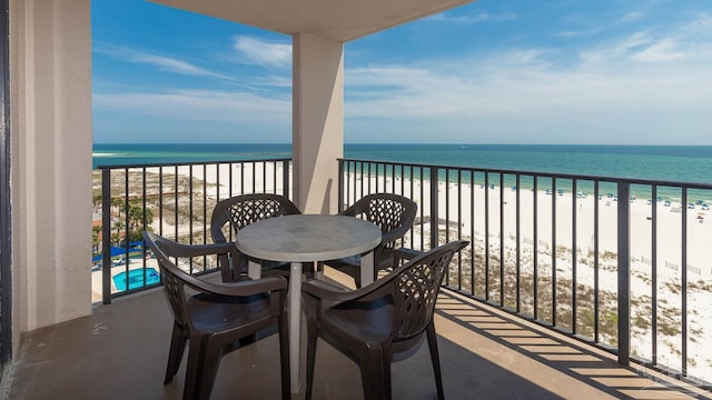 balcony with a water view and a view of the beach