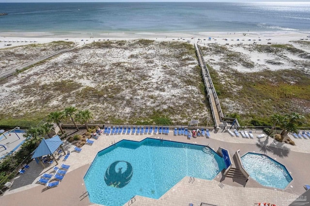 pool featuring a water view, a beach view, and a patio