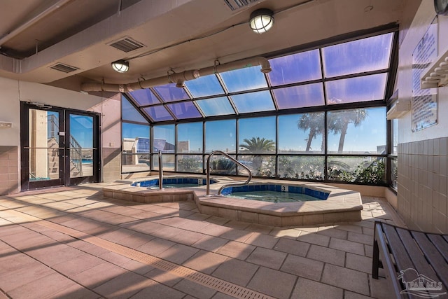 outdoor pool with an in ground hot tub, a patio, and a lanai