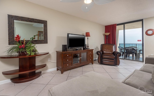 living room with ceiling fan, light tile patterned flooring, and expansive windows