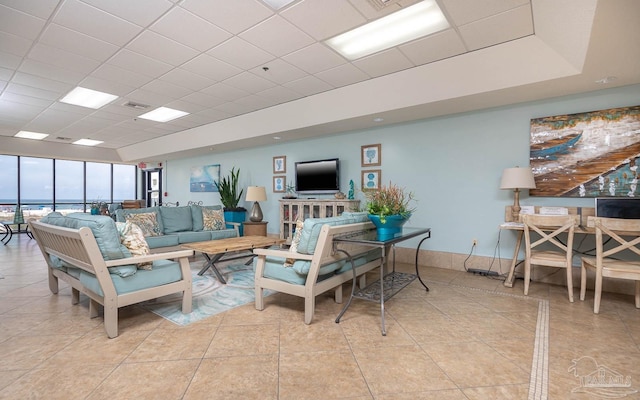 living room featuring light tile patterned flooring and a drop ceiling