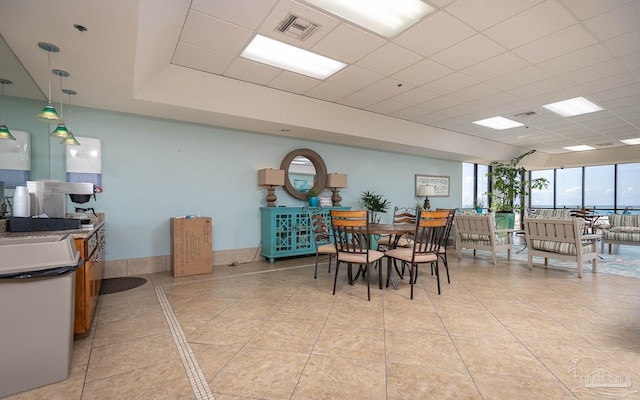 dining room featuring light tile patterned flooring, baseboards, a drop ceiling, and visible vents