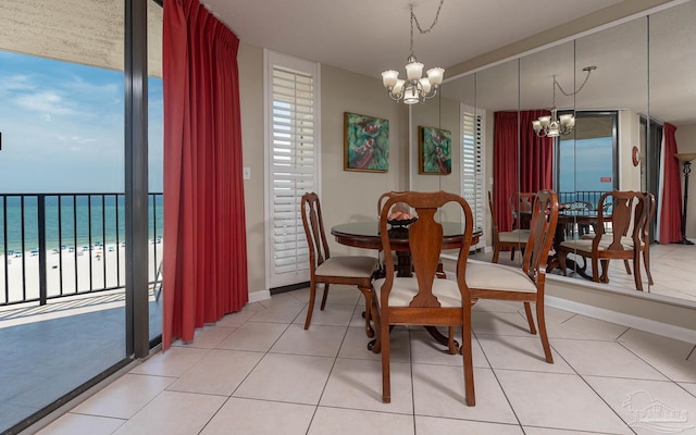 dining space with a water view, a wealth of natural light, an inviting chandelier, and baseboards