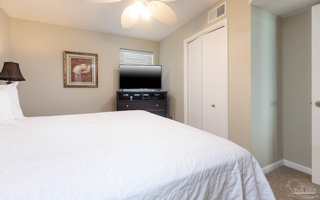 carpeted bedroom featuring a closet, visible vents, baseboards, and a ceiling fan