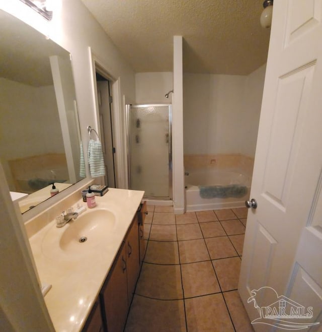 bathroom with vanity, tile patterned floors, a textured ceiling, and plus walk in shower