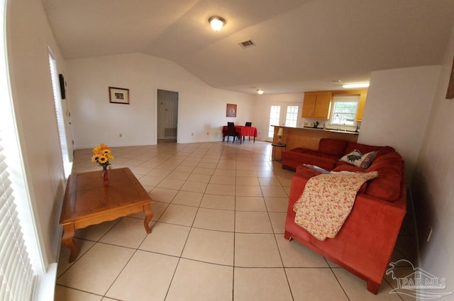 tiled living room featuring vaulted ceiling