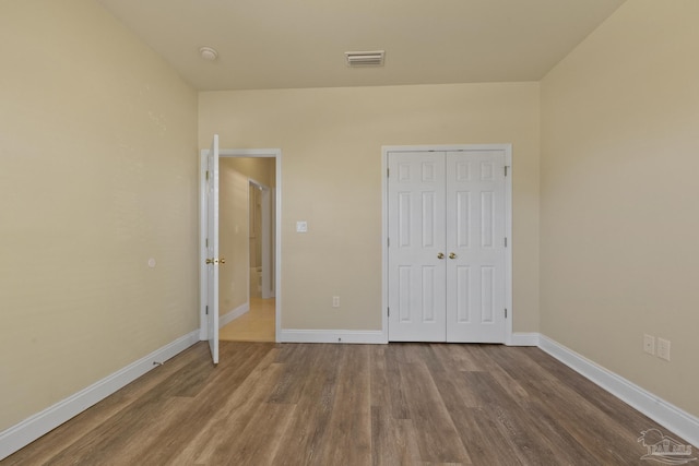 unfurnished bedroom featuring hardwood / wood-style floors and a closet