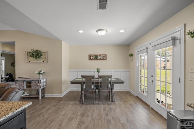 dining room with light wood-style floors, french doors, visible vents, and baseboards