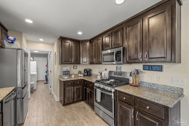 kitchen featuring light stone counters, dark brown cabinetry, appliances with stainless steel finishes, and light wood finished floors